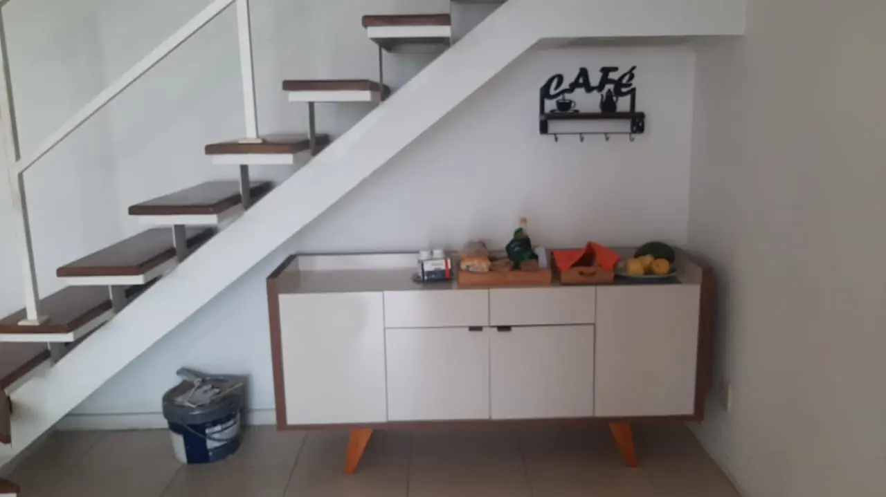 Móvel sob a escada com portas brancas
